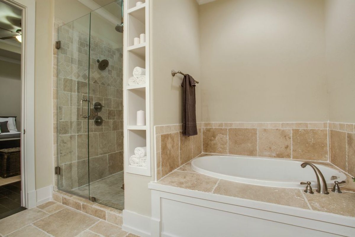 Primary bath: soaking tub, frameless glass, travertine.